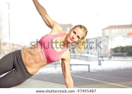 Young beautiful woman doing core exercise outdoor