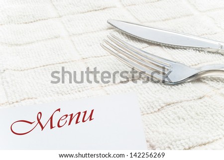 menu card fork and knife on table cloth