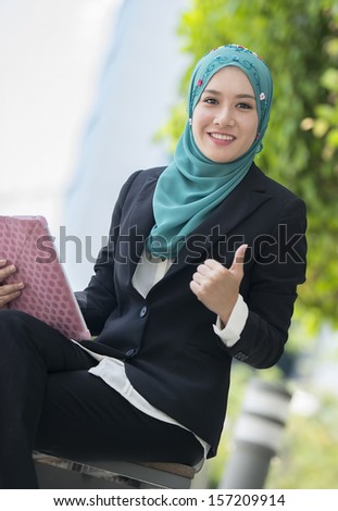 Young pretty business woman wearing scarf thumbs up