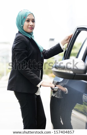 Image of Executive women with scarf woman want to enter her car
