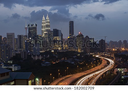 Stunning light trail from the busy highway traffic and Kuala Lumpur twin towers as a background