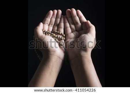 hand holding a muslim rosary and pray to god