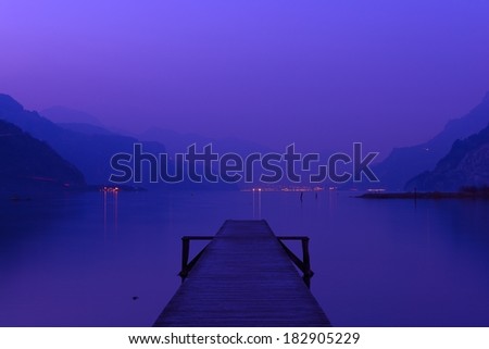 Evening on the lake in Switzerland. Water and mountains painted in pink and purple colors