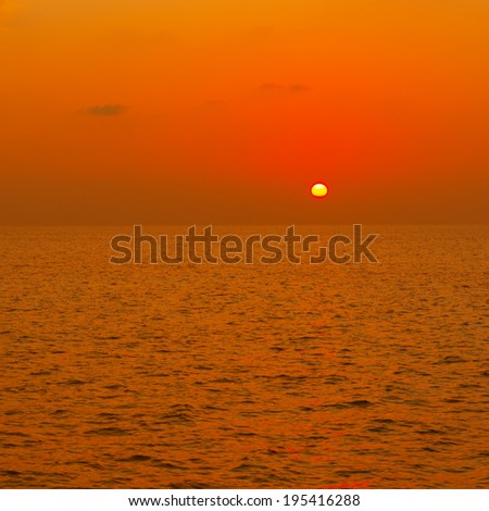 Sunset over the sea. Rays of the sun through the clouds. Setting sun painted the sky  in bright color.
