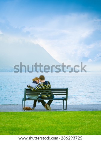 Brunnen, Switzerland- June 11, 2013. One pair of lovers, a young girl with red hair and a guy sitting on a bench by the lake.