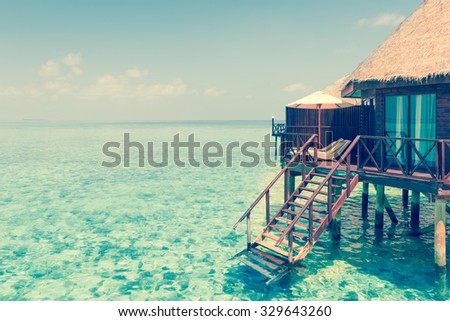Panorama of tropical island resort with over water bungalows at night. Maldives. Ari Atoll.