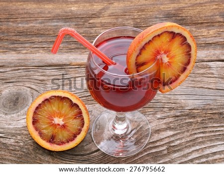 Blood orange cocktail with slices of blood orange on wooden table