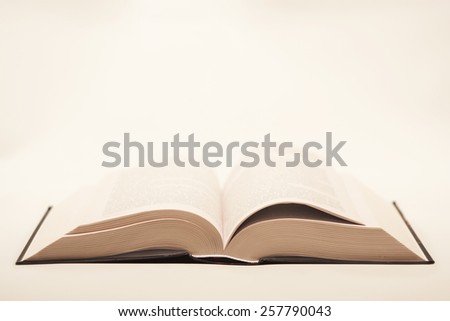 quite old but not damaged open book lying on the table on a light background