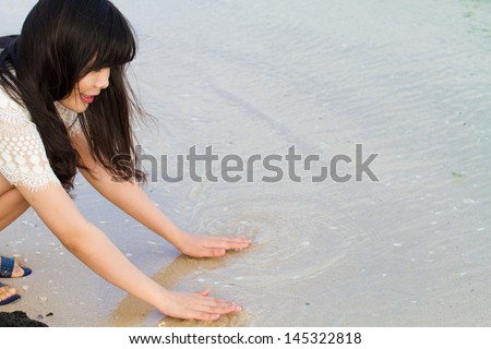 Girl plays with water at the sea