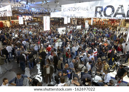 MILAN, ITALY - NOVEMBER 8: People visit  motorcycles and scooters exhibition area at EICMA, 71st International Motorcycle Exhibition on November 8, 2013 in Milan, Italy.