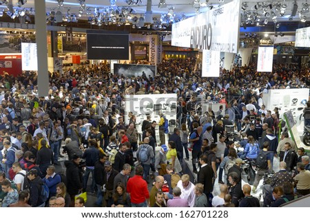 MILAN, ITALY - NOVEMBER 8: People visit  motorcycles and scooters exhibition area at EICMA, 71st International Motorcycle Exhibition on November 8, 2013 in Milan, Italy.