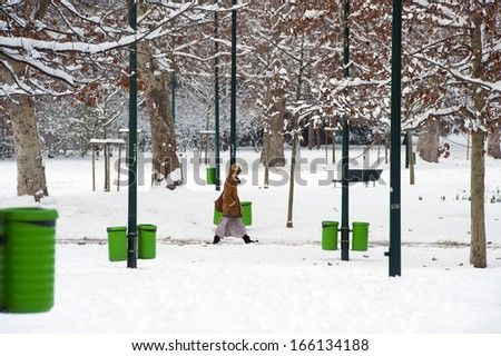 MILAN, ITALY - FEBRUARY, 02: a woman walking in a public park covered with snow, in Milan. Milan, February 02,2012
