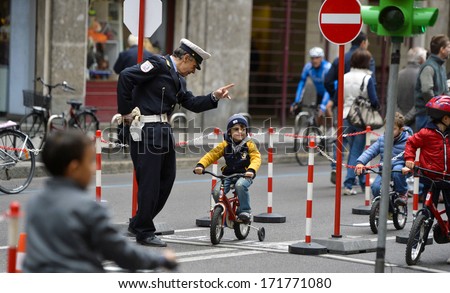 MILAN, ITALY - OCTOBER 14: Policeman teaches children to recognize traffic signals, during a sunday with no cars allowed in the streets of Milan, October 14, 2012