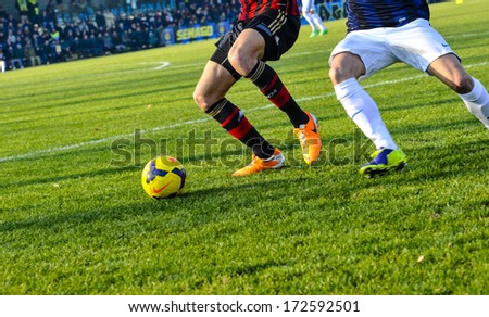 MILAN, ITALY - JANUARY 12 Youth italian soccer match in Milan January 12, 2014. A football players close up action with the green pitch on the background.