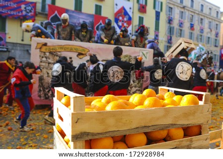 Ivrea, Italy - February 15: Oranges Case To Throw Is Waiting As Masked People Fight During The Traditional Carnival Parade Of Oranges Battle In Ivrea February 15,2010.