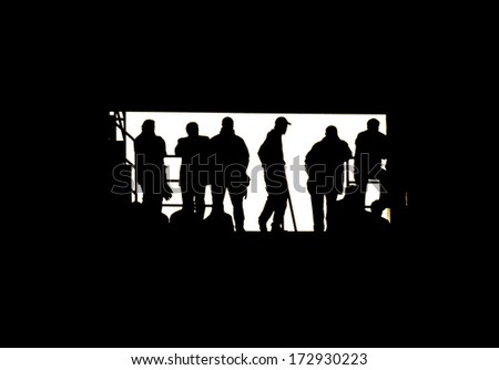 Tunnel vision of silhouetted young men at the stadium watching a soccer match.