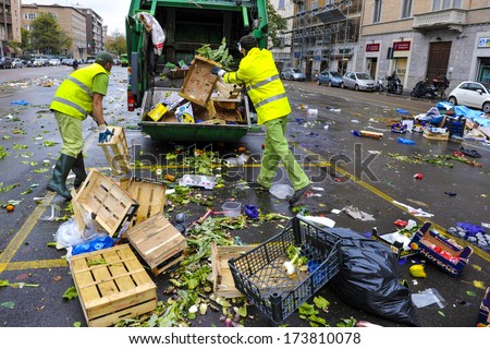 MILAN, ITALY - NOVEMBER 08: Garbage man collecting garbage in the garbage truck, after a street food market in Milan November 08, 2011.