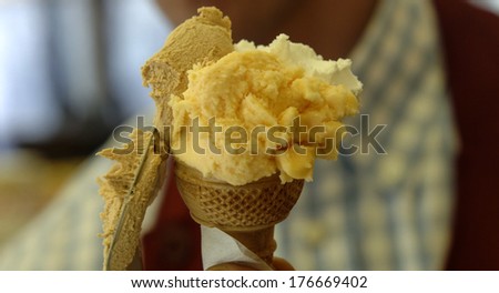 Close up of an ice cream maker preparing a vanilla and cream waffle cone.