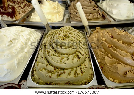 Pistachio ice cream and cream flavors are shown inside an italian ice cream parlor.