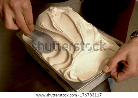 Ice cream maker scooping a vanilla flavor.