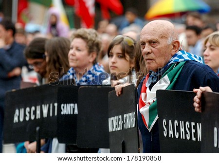 MILAN, ITALY-APRIL 26, 2006: Survivor and younger people holding banners with names of the nazi camps, during the anniversary of Italy\'s freedom from the german occupation in the second world war.
