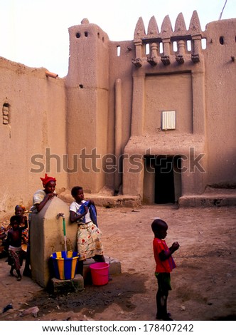 DJENNE\', MALI-AUGUST 24, 2006: Well water in front of a mud house building.