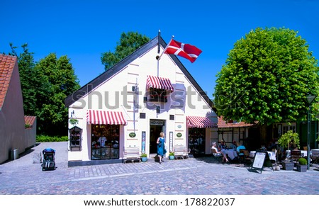 ODENSE, DENMARK-FEBRUARY 17, 2012: Danish flag on top of a souvenir shop on the street of the Hans Christian Andersen house museum.
