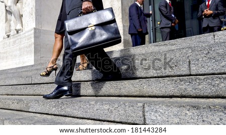 MILAN, ITALY-SEPTEMBER 13, 2012: Businessman holding a briefcase, gets down the Stock Exchange building\'s stair, in Milan.