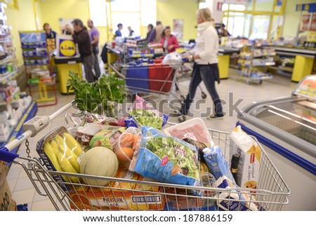 VARESE, ITALY-APRIL 11, 2014: Full shopping cart in front of the cash registers, in a supermarket in Varese.