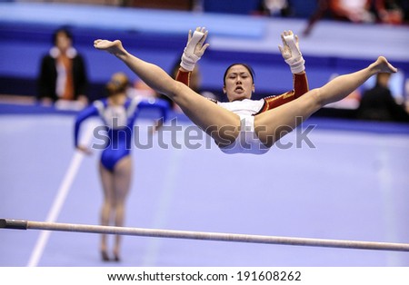 MILAN, ITALY-APRIL 02, 2009: a female gymnast playing high bar exercise, during the European Artistic Gymnastic Championship, in Milan.