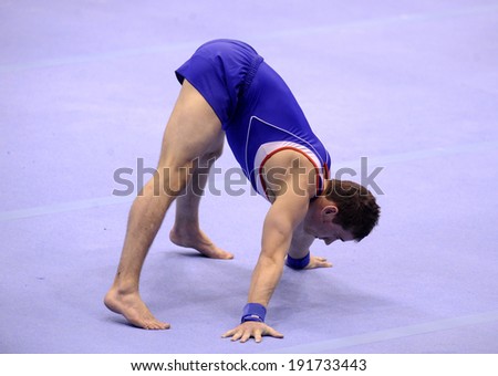 MILAN, ITALY-MARCH 31, 2008: a man athlete performs on gymnastic floor exercise, European Artistic Gymnastic Championship, in Milan.