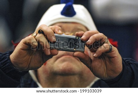 PARIS, FRANCE-OCTOBER 14, 2007: french rugby fan taking picture with an handy camera during the Rugby World Cup match France vs England, in Paris.