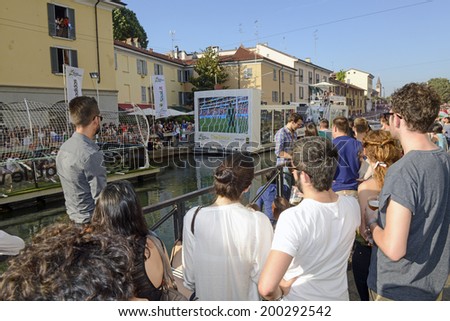 MILAN, ITALY-JUNE 20, 2014: italian soccer fans on the Naviglio Grande canal, watching on a wide screen tv the Brazil 2014 World Cup football match Italy vs Costa Rica, in Milan.