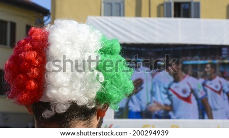 MILAN, ITALY-JUNE 20, 2014: italian soccer fan with italian wig watching the Brazil 2014 World Cup football match Italy vs Costa Rica, in Milan.