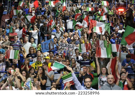 MILAN, ITALY-OCTOBER 10, 2014: italian fans cheering and waving national flags during the indoor female volleyball match Italy vs Russia of the Volleyball World Cup, in Milan.