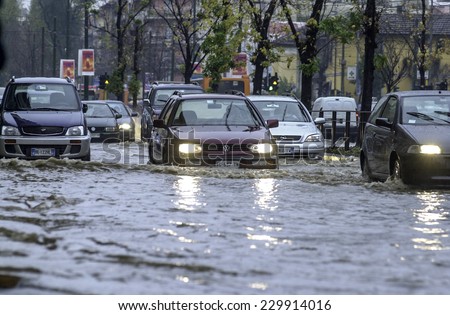 MILAN, ITALY-NOVEMBER 26, 2002: cars driving on a flooded road during a flood caused by heavy rain, in Milan.