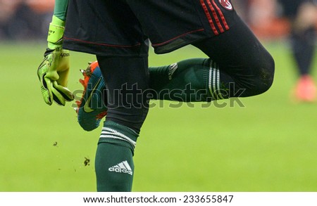 MILAN, ITALY-NOVEMBER 23,2014: AC Milan goalkeeper remove mud from his shoes during the soccer match AC Milan vs FC Internazionale, at the san siro stadium, in Milan.