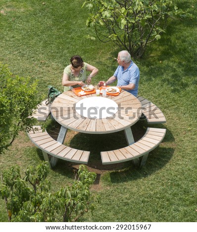 MILAN, ITALY-JUNE 05, 2015: couple eating lunch at a round wooden table at EXPO 2015, in Milan.
