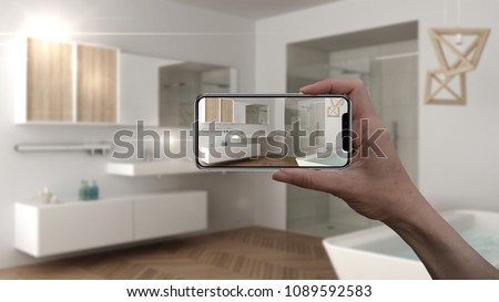 Hand holding smart phone, AR application, simulate furniture and interior design products in real home, architect designer concept, blur background, scandinavian bathroom, 3d illustration