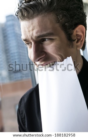 sad and frustrated business man eating paper