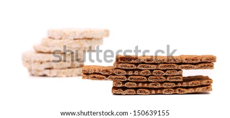 Two stacks. Puffed rice snack and grain crisp bread. White background.