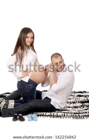 Happy men listen belly of pregnant woman. Isolated on a white background.