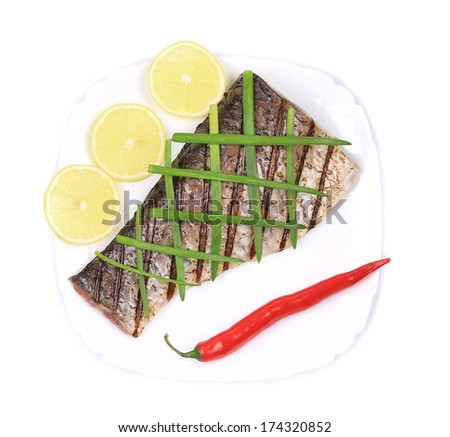 Grilled carp fillet on plate with onion and lemon. Isolated on a white background.
