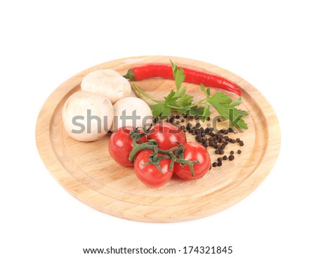 Vegetables on wooden platter. Isolated on a white background