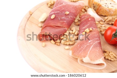 Composition of prosciutto on wooden platter. Whole background.