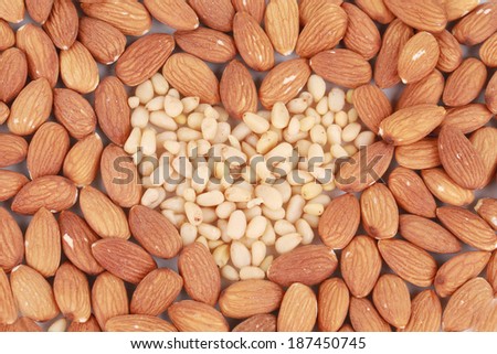 Heart shape of almonds and pine nuts. Whole background.