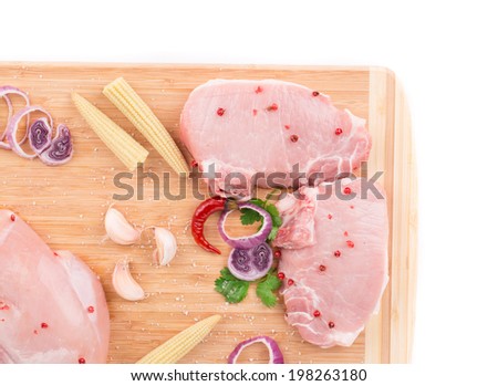 Meat composition on wooden platter. Isolated on a white background.