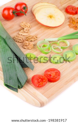 Vegetables on wooden platter. On a white background.