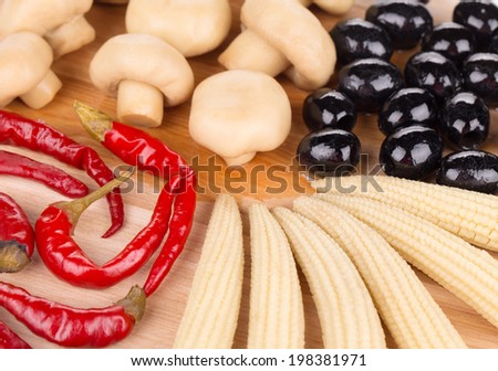 Marinaded vegetables on wooden platter. Isolated on a white background.