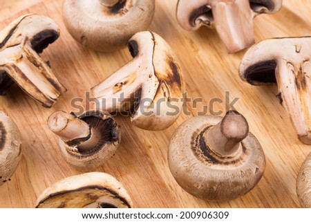 White mushrooms on wooden board. Isolated in closeup.